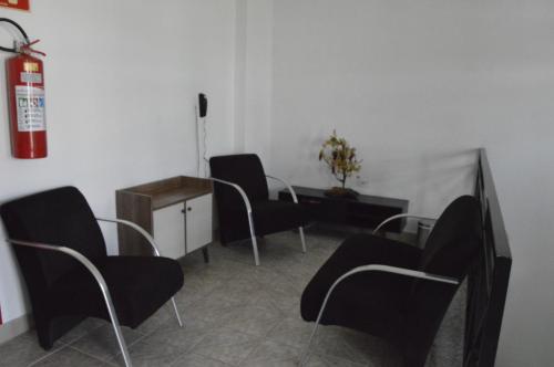 a room with chairs and a table and a fire extinguisher at Hotel Cuca Fresca in Cotia