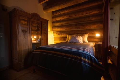 a bedroom with a bed and a wooden wall at Adams Rest cabin in The Dalles
