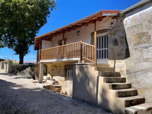 a stone building with stairs and a balcony at Casa do Terrado in Tourém