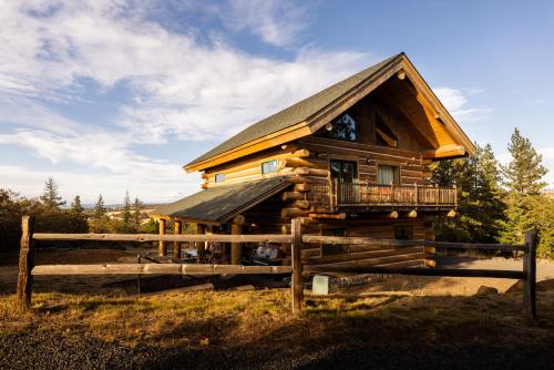 a log cabin with a balcony and a fence at Adams Rest cabin in The Dalles