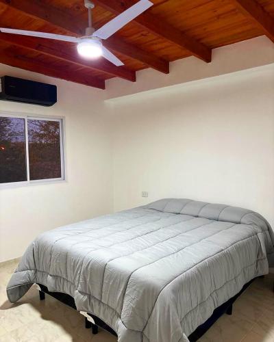 ein Schlafzimmer mit einem Bett mit Deckenventilator in der Unterkunft Finca el Zanjón Punto Alquileres in Santiago del Estero