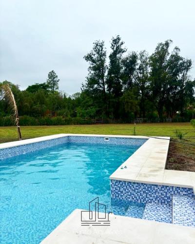 ein großer Pool mit blauen Fliesen im Hof in der Unterkunft Finca el Zanjón Punto Alquileres in Santiago del Estero