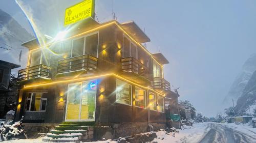 a building in the snow with lights on it at Glampfire Hotel and Cafe in Jispa