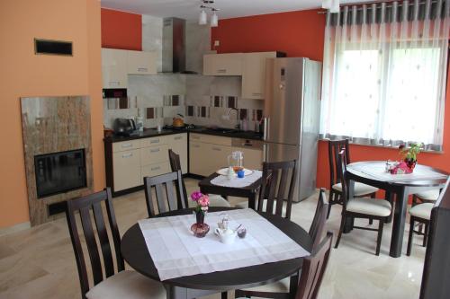 a kitchen and dining room with two tables and chairs at Willa Olympia in Unieście