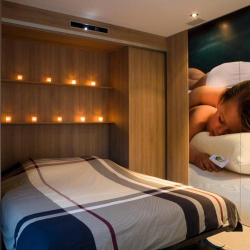 a woman sleeping on a bed in a bedroom at Sauna cottage in Tielt
