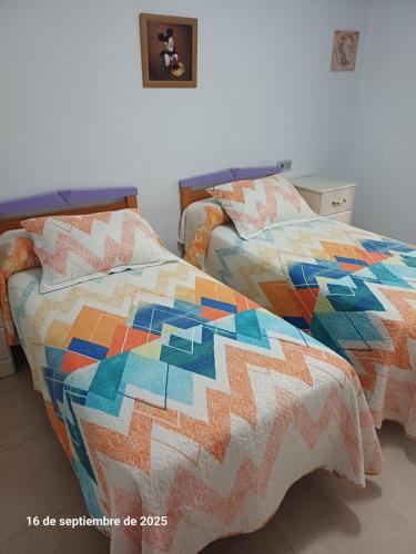 two beds with a quilt on them in a bedroom at Cortijo del carmen in Moratalla