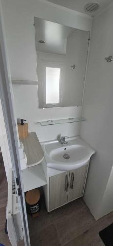 a bathroom with a sink and a mirror at mobile home camping la pignade in La Tremblade