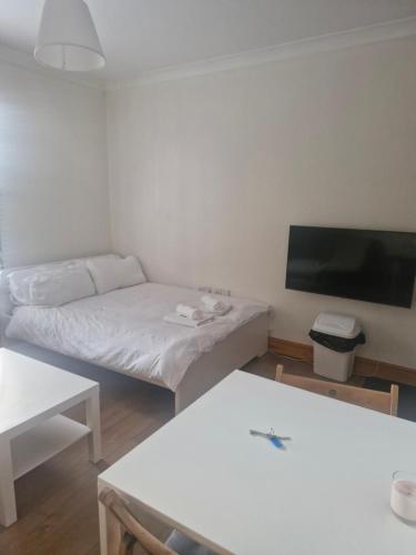 a small room with a bed and a flat screen tv at Your home away from home in Highgate in London