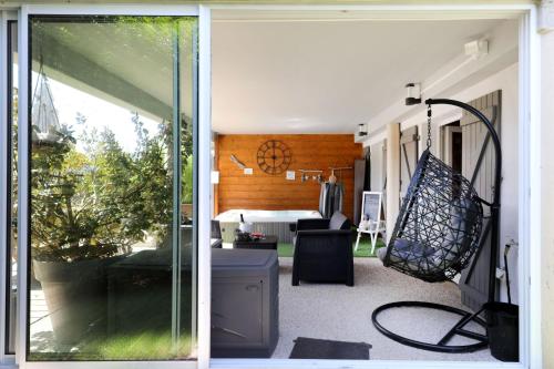 an open door to a patio with a hammock at AU NID COSY D'ISA A GERARDMER VOSGES - Spas privatifs in Gérardmer