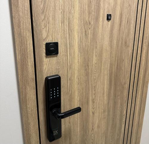 a wooden door with a black door knocker on it at Apartments Жк Respublika новая евродвушка in Astana