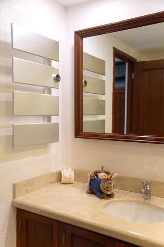 a bathroom with a sink and a mirror at Spacious and elegant vacation home for 6 people in a private condominium in Playa del Carmen