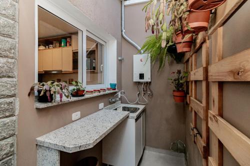 a small kitchen with a sink and a counter at Casa Paris em condomínio até 8 p in Canela