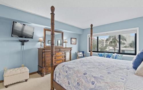 une chambre avec un lit et une télévision à écran plat dans l'établissement Oceanfront Two Bedroom Condo with Balcony and Heated Pool, à Cocoa Beach