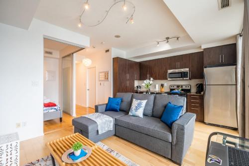 a living room with a couch and a kitchen at The Roland - Luxury Suite w Stunning City Views in Toronto