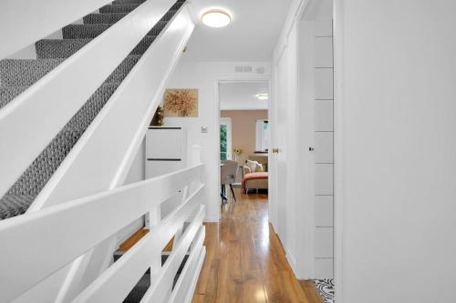a staircase in a house with white walls and wood floors at FREE parking - modern apartment in SW London in Merton