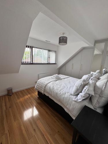a white bedroom with a bed and a window at FREE parking - modern apartment in SW London in Merton