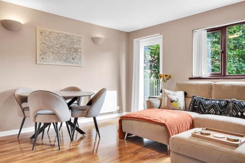 a living room with a couch and a table and chairs at FREE parking - modern apartment in SW London in Merton