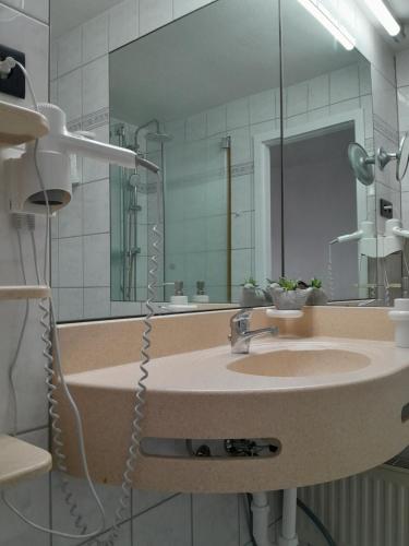 une salle de bain avec un lavabo et un grand miroir dans l'établissement Ferienwohnung Marina in Sankt Englmar, Bayerischer Wald, familienfreundlich, à Sankt Englmar