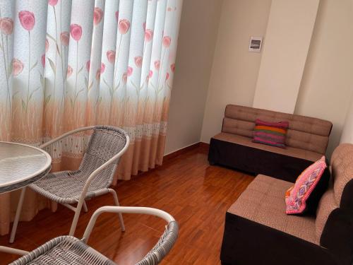 a living room with a couch and a table and chairs at Habitación matrimonial con jacuzzi in Huayllabamba