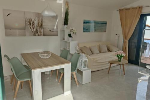 a living room with a table and a couch at Apartment - Sleeps 4 - Pool - Parking in SantʼAndrea Apostolo dello Ionio