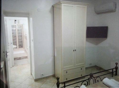 a white cabinet in a room with a window at Apartment La Maison in Messina