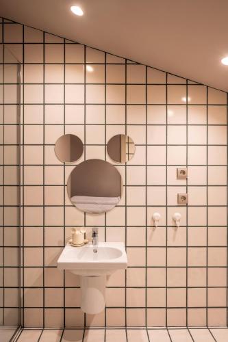 a bathroom with a sink and a tiled wall at Grande Hotel Thermas Nature & SPA in Termas de Sao Pedro do Sul