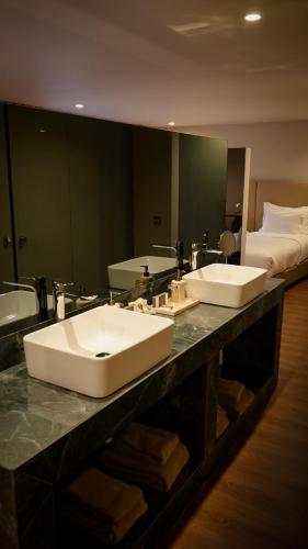a bathroom with two sinks and a large mirror at Grande Hotel Thermas Nature & SPA in Termas de Sao Pedro do Sul