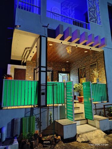 a building with green shutters and stairs on it at Shree Datt Yatri Niwas Akkalkot in Solapur