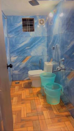 a bathroom with a toilet and a blue wall at The soul view homestay in Suryanelli