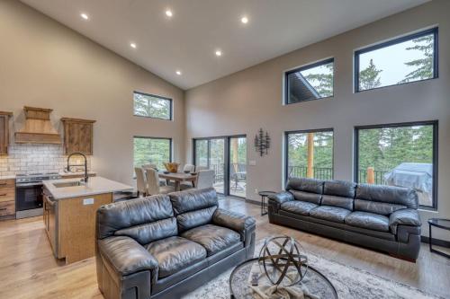 a living room with two leather couches and a kitchen at Shadow Pines Lodge in Kirk