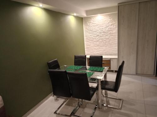 a dining room with a glass table and black chairs at Srebrny Apartament in Skarżysko-Kamienna