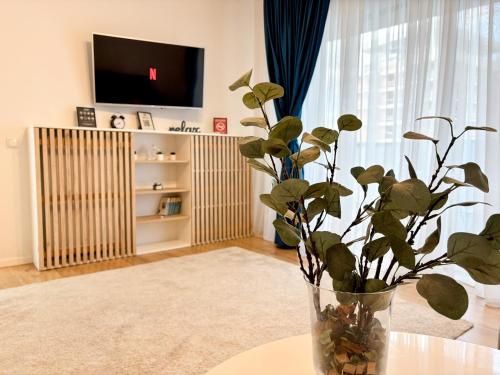 eine Vase mit einer Pflanze auf einem Tisch im Wohnzimmer in der Unterkunft The Oasis in Someşeni