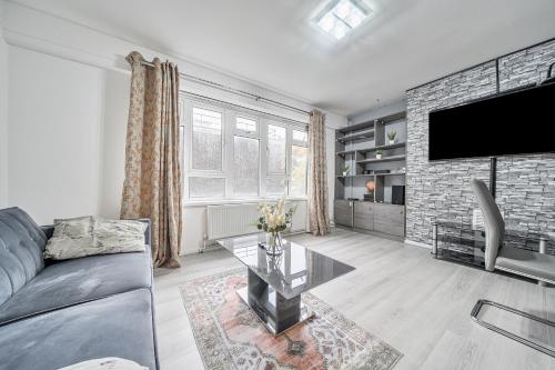 a living room with a couch and a tv at Comfortable and Modern 2-Bedroom Greenwich Apartment in London