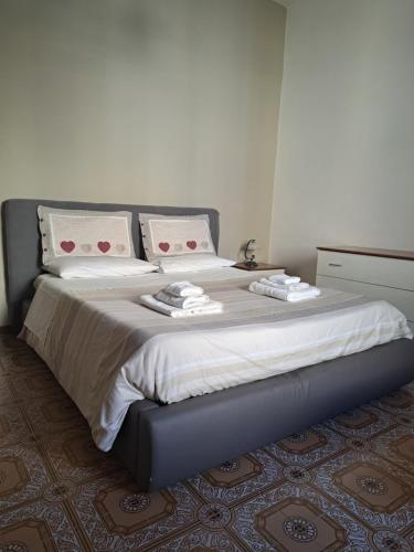 a bedroom with a large bed with two pillows at Due finestre sul cortile in Novi Ligure