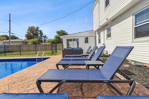 Ultimate Group Escape Heated Pool - 12 Guests في Seven Hills: صف كراسي الجلوس بجانب المسبح