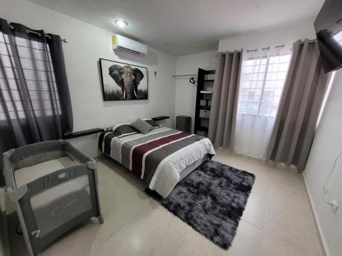 ein Schlafzimmer mit einem Bett und einem Elefantenbild an der Wand in der Unterkunft Casa Izamal Mérida in Mérida