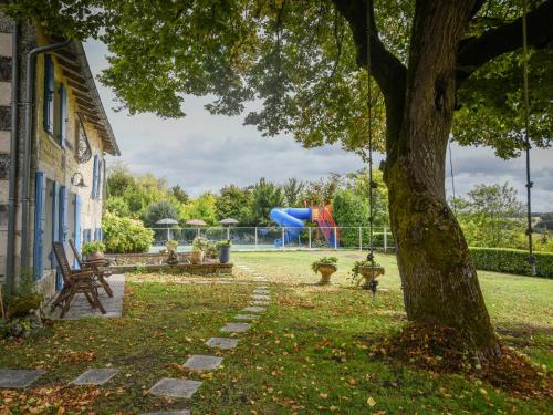 a yard with a playground and a tree at Maswari en Drapeau in Lusignac