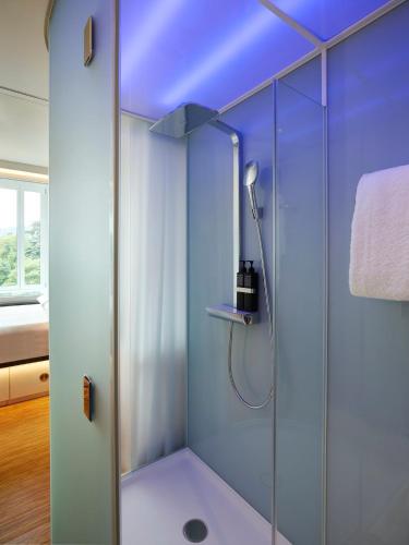 a shower with a glass door in a bathroom at citizenM Zürich in Zürich