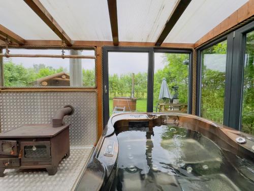 a jacuzzi tub in a room with windows at wellness vagon in Chlum u Třeboně