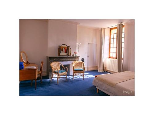 ein Schlafzimmer mit einem Tisch, einem Bett und einem Schreibtisch in der Unterkunft Gites Aubelle - La Maison Aubelle in Montreuil-Bellay