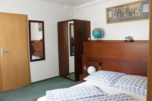 a bedroom with a bed and a headboard and a mirror at Pension Pieschen Dresden in Dresden