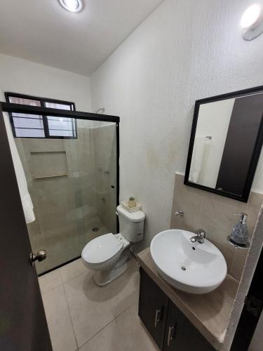 a bathroom with a toilet and a sink and a shower at Casa Izamal Mérida in Mérida