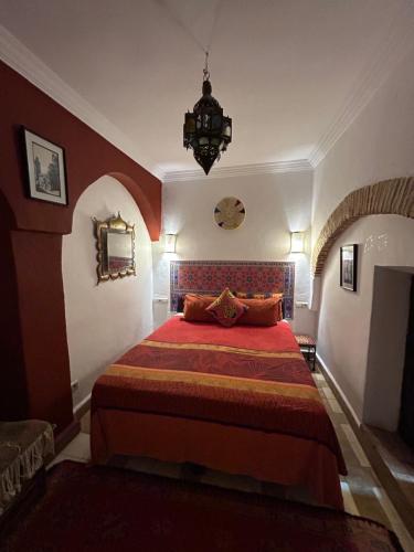 a bedroom with a bed with a red bedspread at Riad N10 in Marrakech