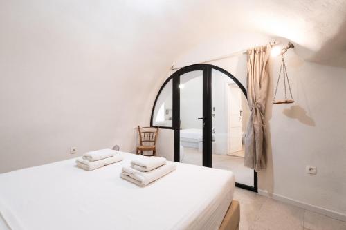 a bedroom with a bed with two towels on it at Mantilida Villa in Emporio Santorini