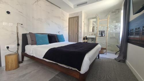 a bedroom with a large bed with blue pillows at Le Petit Trianon et le Charme des Suites in Nice