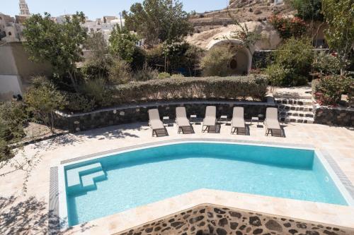 a swimming pool with lounge chairs and a swimming pool at Mantilida Villa in Emporio Santorini