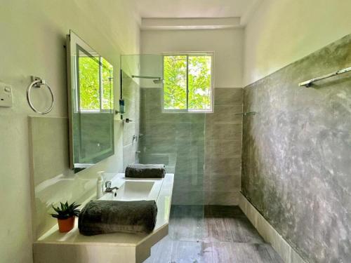Un baño con bañera, lavabo y ducha. en Monkeys Lodge, en Seeduwa