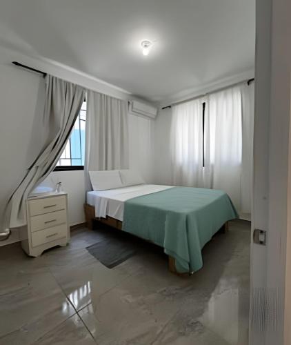 a bedroom with a green bed and a window at habitacion a 100 pasos de la playa in Sampiño