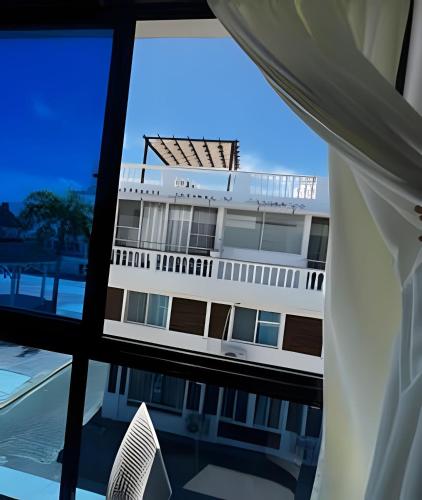 a view of a building from a window at habitacion a 100 pasos de la playa in Sampiño