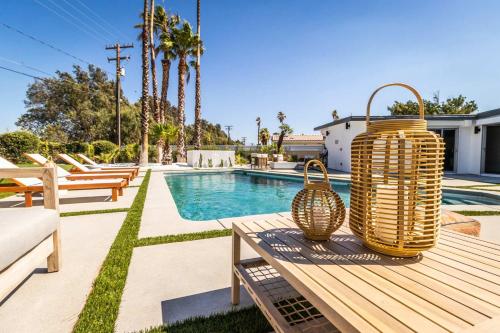 a picnic table with two wicker baskets on it next to a pool at Architectural Villa for Groups 16 Pax in Palm Springs